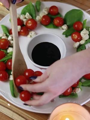 One of my favorite Christmas appetizers to serve ❤️ ✨INGREDIENTS ✨  * 50 cherry or grape tomatoes * 24 fresh basil leaves, cut in half * 15 oz. Mozzarella cheese, cut into 24 1/2 inch squares * 1 tsp Italian seasoning * 1 tsp olive oil  * 3 Tablespoons rosemary balsamic dressing #easyappetizers  #christmasappetizer #newyearsappetizer  #appetizerideas  #wreathappetizer 