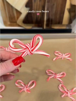 Peppermimt candy cane bows!  Preheat oven to 175 degrees. Cross 2 candy canes on parchment paper in the shape of a heart. Bake for 10 min. Immediately pinch the center to mold a bow shape.  Next, break off a rounded piece of another candy cane and place over the center of the bow and put back in the over for another 10 min. Immediately pinch center to secure the bow shape. (The peppermint cools fast so you have to be quick). Bend the ends of the candy canes to look more like a bow.  #HolidayTreats #christmascandy #peppermint #candycane #bows #bakinghacks #diychristmas #christmasbaking 