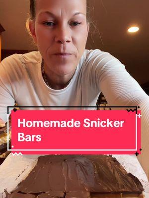 Homemade Snicker Bars😋 Layer 1-chocolate layer 1 1/4 chocolate chips  1/4 cup peanut butter Melt in the microwave in 30 second intervals  Spread onto a parchment lined 9x13 pan and refrigerate  Layer 2-nougat layer 1/4 cup butter 1 cup sugar 1/4 cup evaporated milk  7oz jar marshmallow fluff 1/4 cup peanut butter 1tsp vanilla 1 cup chopped peanuts Melt butter over medium heat, add sugar and evaporated milk, stir until dissolved.  Bring to a slow boil and cook for 5 min stirring constantly.  Add Marshmallow fluff, peanut buttet and vanilla.  Once mixed and smooth fold in your crushed peanuts.  Add the nougat layer on top of chocolate layer.  Refrigerate  Layer 3-caramel layer 14oz bag of caramels(I used about 45-50 caramels) 1/4 cup heavy whipping cream Cook until melted and add that on top of nougat layer.  Refrigerate  Layer 4 Repeat layer 1-chocolate layer 1 1/4 cups chocolate chips 1/4 cup peanut butter  Melt in 30 second intervals until melted.  Pour over caramel layer and refrigerate for at least an hour.  Remove from pan and cut into bars #snickers #snickerbars #homemadesnickers #candy #candyrecipe #candybar #dessert #sweets #candytok #recipesoftiktok #Recipe #Foodie #mukbang #foodietiktok #christiecrocker #christiecrockerskitchen #lymphoma #follicularlymphoma #lymphomawarrior   Snicker Bars Homemade Snicker Bars @karinne◡̈ 😋😋😋😋@Cece 🫰🏼💜💜 