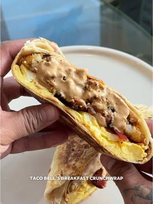 Recipe ⤵️ Quick Taco Bell Breakfast Crunchwrap 🍳🥓🤍🌯 Ingredients: Crunchwrap  - 8 hashbrowns  - Pack of bacon  - Pork breakfast sausage  - 8 flour tortillas  - 8 oz medium cheddar (shredded) - dozen eggs - 2 tbsp unsalted butter  Jalapeño Swauce: - 3/4 kewpie mayo  - 1/2 sour cream  - 1/2 tbsp jalapeño brine  - 1/8 jalapeños peppers  - 1-2 chipotle peppers  - 1 tsp onion powder  - 1 tsp garlic powder  - 1/4 tsp cumin powder  - 1 tsp paprika  - 1 tsp sugar  - salt to taste (i did 1/2 tsp) - 1/4 tsp white pepper Directions: 1. air fry your bacon at 400 for 8-10 mins depending on how crispy you want it. let it cool & chop it up into bits. 2. air fry your hash browns at 400 for 15-17 mins until they’re nice & golden brown.  3. Add all the ingredients for the swauce into a blender or food processor & blend until smooth. set aside.  4. crack your eggs into a bowl & whisk until no streaks. add to a buttered pan over medium heat and gently push around with a spatula to ensure you get fluffy eggs. (about 3-4 mins) 5. once theyre almost done & not super runny flip them and season w salt, pepper, and a little cheddar. let them cook for a little less than a min. remove from heat & set aside.  6. roll your sausage into equal sized balls. add to lightly oiled skillet over med heat. flatten them down into patties.  7. cook for 2-3 mins per side until it’s done.  8. You’re gonna need two tortilla per Crunchwrap. Cut the center out of one & leave the other whole. 9. Lightly warm up the whole one on a comal until it’s nice & soft. (about 30-40 seconds per side) you don’t want it toasted! 10. Add the eggs, bacon, sauce, 2 hash browns, and cheddar onto center of tortilla. Add the other smaller one on top. Gently fold over the sides of the larger one.  11. Place folded side down onto a hot comal over medium low heat. Once it’s nice and crispy flip it over and cook the other side.  12. Serve w some more of your sauce & some hot sauce on the side & enjoy babe! #tacobell #breakfast #EasyRecipes #brunch #tbell #crunchwrap #breakfastideas 