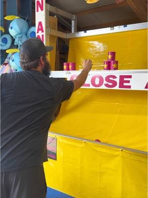 The name of the game is Lean and Toss, but the cans need to fall off the back of the shelf to win! #carnivalgames 