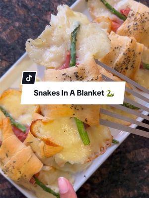 You might be familiar with pigs in a blanket, but have you ever tried this one? 🐍 Ingredients: 1 (10 ounce) can refrigerated crescent roll dough 1 tablespoon olive oil (Optional) 4 slices provolone cheese, halved 4 slices Swiss cheese, halved 4 slices mozzarella cheese, halved 8 asparagus spears, trimmed and cut in half 8 slices prosciutto 2 tablespoons olive oil, for drizzling (Optional) 1 tablespoon dried Italian seasoning (Optional) Directions: Preheat oven to 350 degrees F  (175 degrees C). Lightly grease a baking sheet. Unroll and separate dough into 8 triangles; place on a lightly floured surface. Using 1 tablespoon of olive oil, lightly brush the top of each dough triangle. Place one piece of provolone cheese, Swiss cheese and mozzarella cheese on the wide end of each triangle. Put one piece of asparagus on top of the cheese. Roll each dough triangle around the cheese and asparagus toward the point and press to secure. Arrange on a baking sheet at least 2 inches apart. Bake in preheated oven until lightly brown, 13 to 18 minutes. Remove from the baking sheet to cool on wire racks. If desired, drizzle with 2 tablespoons olive oil and sprinkle with Italian seasoning. 🧑‍🍳: @Jessica Lawson  #pigsinablanket #easyappetizers #crescentrolls #rollups #asparagus