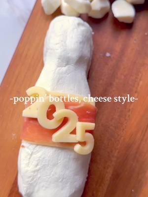 🥂Popping bottles—cheese board style! 🎉 Start the New Year with this festive cheese champagne bottle: 🧀 Shape goat cheese into a bottle while wrapped in plastic wrap—or swap for Boursin or any soft cheese/spread! 🧀 Add a slice of cheddar for the label. 🧀 Top with prosciutto—or swap for salami or sopressata! 🧀 Finish with cheddar numbers for ‘2025.’ ✨ Don’t forget mini mozzarella pearls for the bubbles! #fyp #charcuterieandthings #charcuterieboard #cheeseboard #foodstyling #DIY #foodstyling CheeseChampagneBottle #CharcuterieInspo #newyearscheeseboard #newyearseve 