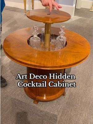 This extraordinary Art Deco pop-up drinks table is a rare example of metamorphic furniture design from the early 20th century. Crafted from fine walnut, it showcases the sleek geometric forms and innovative craftsmanship synonymous with the Art Deco movement. With a gentle press at its center, the table’s top seamlessly elevates to reveal a hidden cocktail cabinet, featuring crystal decanters and glasses, transforming it into an elegant drink-serving area. #antique #antiquebar #drinkscabinet #hiddenfeature #secretbar #artdeco #luxuryhome 