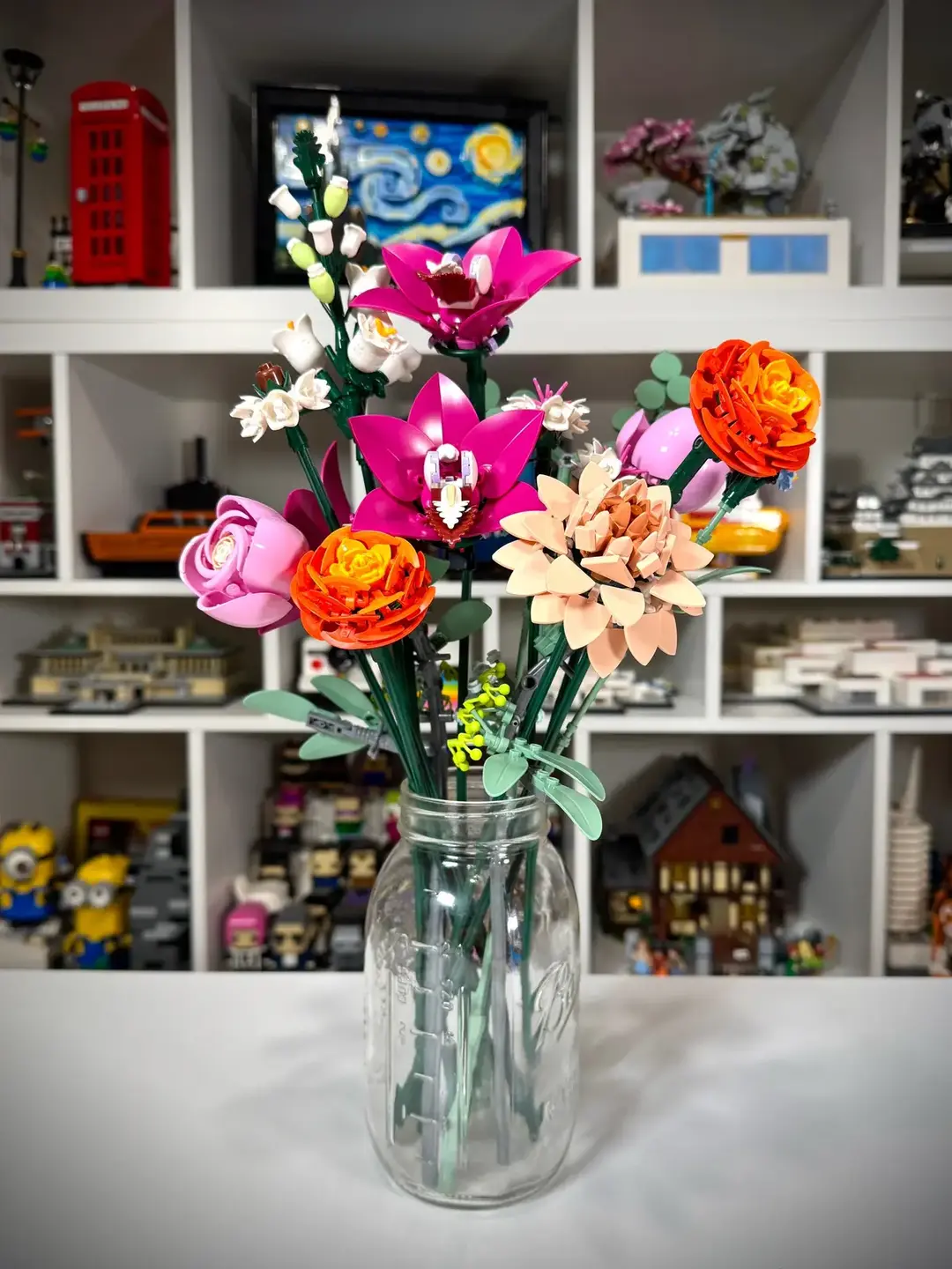 The new @LEGO Pretty Pink Flower Bouquet from the Botanical Collection is available to purchase now for $59.99 USD. To start off, I would like to say that this set showed that I have very little flower arranging skill. 😂 I have built many of the botanical sets, but this is only my second time building a bouquet, the first being the bouquet of roses. I own the other bouquets, I just have not put them together yet. The flowers in this set are beautiful, and I enjoyed putting them together. I did have some issues and made some mistakes, but I blame most of that on being distracted by building this live on social media & big fingers/small pieces. The Persian Buttercup, Waterlily Dahlia & Boat Orchids are my favorites. I love the colors and all the nice parts usage. Axe Heads and Shields and Frogs, Oh My! When I photographed this set, I realized that I do not have a vase, so I went with a trusty mason jar, which is perhaps a little too big for this bouquet. One of the things that I love about the smaller botanical sets is that there is a brick built vase as part of the set. I would love to see vase sets come out in the future so we have a nice place to put our bouquets. Personally, I would not suggest this set to someone who is new to LEGO building, or has never put together a botanical set, there are plenty of others that are good for first timers. Since I haven’t built the other bouquet sets except for the roses, I can’t give a comparison to say if this set is  better or worse than previous ones. Overall, if you have enjoyed other kinds of botanical sets, I think you will enjoy this one as well. 10342 - Pretty Pink Flower Bouquet - 749 pieces - $59.99 USD Thank you to The LEGO Group for gifting me this set to build, share & review. #NeedMoBricks #LEGO #LEGOBotanical #FlowerBouquet #PrettyPink #10342 #Review #RLFM #AFOL