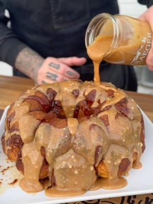 Peanut Butter Monkey Bread 🤤  350°  for about 35 to 45 minutes. Glaze on raw biscuit dough before going on the grill is 3/4 melted butter and 3/4 cup brown sugar. Peanut Butter Glaze: 3/4 melted peanut butter  2 cups powdered sugar  1/2 cup milk Whisked together over low heat. This dessert disappears quickly. #traegergrills #kendrickbbq #monkeybread #peanutbutter #reeses #sweettooth #bbq #ramsayreacts @Gordon Ramsay  @Traeger Grills @Pillsbury @Reeses 