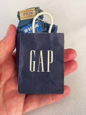 Happy Miniature Monday! ✨👖 A perfectly scaled-down pair of Gap jeans, complete with its own tiny shopping bag! Every detail is spot-on, from the classic Gap Blue Jeans label to the delicate price tag. It's amazing how they captured the authentic denim texture at such a tiny scale! This charming piece is part of a special 1996 collector's collaboration. Love how they included the miniature shopping experience - it really brings back memories of those iconic blue Gap bags! Perfect for any miniature enthusiast or fashion history buff. Who else gets excited about perfectly executed mini replicas like this?  #MiniatureMonday #TinyTreasures #VintageMinis #MiniatureFashion #1990sNostalgia