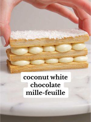 coconut white chocolate mille-feuille inspired by my favorite candy, raffaello 🥥 it’s got a white chocolate coconut cremeux sandwiched between homemade puff pastry + it’s garnished w/ more white chocolate + coconut! full recipe is on my bloggg #millefeuille #pastrychef #patisserie #relaxing #aesthetic #creamy 