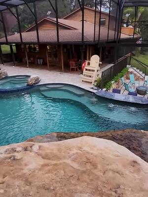 This backyard has a huge grotto, a waterslide, a big spa, a swim-up bar, a screened enclosure, a fire pit, and a lifeguard stand.   #insanepools #lucaslagoons #pool #poolbuilders #backyard #luxurylife #waterslide 