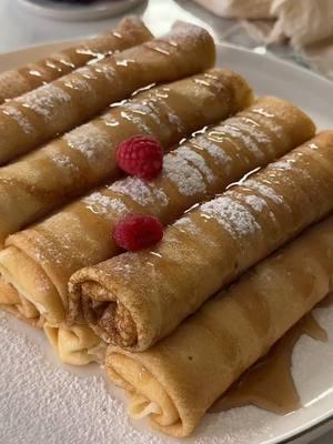 The only cheese blintzes recipe you’ll ever need (really) by @adimarom5 Batter: 4 eggs 1½ cups/360 milliliters milk 1 cup/240 milliliters water 3 tablespoons sugar 1½ cups/190 grams flour Filling: 8 ounces/225 grams cream cheese 9 ounces/250 grams full fat Greek yogurt 1 cup/250 milliliters heavy whipping cream 1/3 cup sugar 2 tablespoons/20 grams instant vanilla pudding 1 teaspoon vanilla bean paste In a medium bowl, combine the cream cheese, Greek yogurt, heavy whipping cream, sugar, vanilla pudding mix, and vanilla bean paste. Using a hand mixer, whip the mixture until it forms a stable, creamy texture. Set aside. In a large bowl, whisk together the eggs, milk, water, and sugar until fully combined.  Gradually add the flour, whisking continuously, until the batter is smooth and free of lumps. Heat a lightly greased skillet over medium heat. Pour a small amount of batter into the pan, swirling to coat the surface evenly. Cook each blintz for about 40 seconds on one side, until golden, then flip and cook for another 40 seconds. Transfer to a plate and repeat with the remaining batter. Allow the blintzes to cool slightly. Using a piping bag, fill each blintz with the prepared cheese filling. Roll them tightly and arrange on a serving platter. Dust with powdered sugar, drizzle with maple syrup, and garnish with fresh berries. Serve immediately and enjoy! #yummyeasysnacks #tiktokcookingvideos #delicacyfood #cheeseblintzes​  #blintzesrecipe