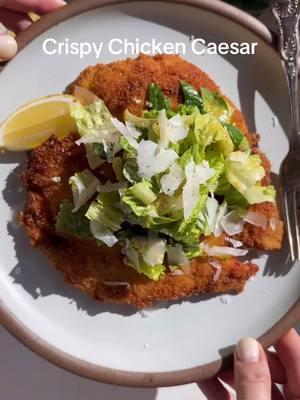 Chicken Milanese & Caesar Salad! As a non chicken lover... I've been trying to love it and this might be one of the best combinations known to man. Brining the chicken is optional but recommended so it's super moist! I did 2 cups water & 2 tbsp kosher salt. You boil the water with the salt and let if cool. Brine chicken for 4-12 hrs. Rinse and pat dry. Ingredients: * 2-3 large chicken breasts. * 1/3 c flour. * 1 1/2 cup panko. * 2 eggs. * 2 tbsp milk. * 1 egg yolk. * 3 anchovies. * 1/2 garlic clove. * 1/4 cup freshly grated parmigiano reggiano + more for shaving over the salad. * 1/2 lemon + more for serving. * 1/4 tsp worcestshire. * 1-2 squirts of tabasco. * 1/3 cup  olive oil. * 1 tsp dijon mustard. * salt and pepper to taste (I used my seasoned salt). * 1 tsp dried oregano. * 4-6 cups chopped romaine hearts. Directions: 1. Slice the brined chicken breasts, then pound until desired level of thickness. 2. Whisk the egg with milk and strain onto a plate. 3.  Mix the flour with salt, pepper and oregano. 4. Coat the chicken well on both sides with the flour, dredge with the egg and coat with the panko. Let it sit for 15-25 min on a wire rack. 5. Chop the anchovies and garlic together, forming a paste with the back of your knife. 6. Add the yolk, dijon, garlic and anchovy paste to a bowl. Mix well. Add in the parm, worcestshire, tabasco and some lemon. Don't add the whole thing, taste and adjust. Mix well. Emulsify the olive oil until smooth. Adjust salt/pepper to taste. 7. Preheat a pan on medium high for 2-3 min. Add plenty of olive oil and lower to medium high. 8. Fry the chicken breasts on medium high until golden on both sides, about 2-3 min per side. Remove from the pan. 9. Mix the salad with the dressing. 10. Top with the salad, more parm and black pepper. #chicken #chickenmilanese #chickencaesar #crispychicken