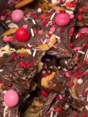 Christmas Crack 🤝🏽 Valentine’s Day. Follow my Instagram linked in my bio where I will be posting this style of content if you know what happens 💞🫶🏽 #christmascrack #toffeerecipe #homemadetoffee #chocolatedippedtreats #valentinesdaydessert #valentinesdaytreats #easydessert #quickandeasyrecipe #fyp  Recipe: **In this video, I doubled the following measurements to make 2 pans, this recipe is for 1 pan! 24 Ritz Crackers 1/2 cup unsalted butter  1/2 cup light brown sugar (I only had dark on hand but I prefer light for this recipe) 4 oz semi sweet chocolate  2 oz white chocolate  Sea salt  (For toppings I used strawberry m&ms & sprinkles found at Target!) 1.) Preheat oven to 425F. Line a 9x13 oven safe pan with parchment paper. 2.) Lay crackers in an even layer in the bottom of the pan. 3.) Melt butter and brown sugar over medium high. Stir til mixture is evenly incorporated and begins to boil. Turn down to medium and boil approximately 5 minutes without stirring.  4.) Remove from heat and pour over crackers. Bake approximately 5 minutes in preheated oven until sauce just starts to bubble.  5.) Remove from oven, cover in chocolate letting it melt then spread it evenly over the toffee sauce. Sprinkle with sea salt and toppings.  6.) Cover & transfer to freezer to fully solidify then break apart & enjoy!