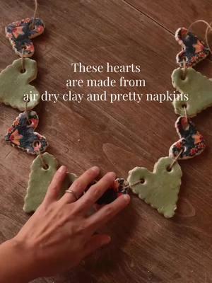 These clay hearts are so easy to make. All you need is air dry clay and pretty napkins. Roll out your clay to about a quarter of an inch in thickness and separate the layers of your napkin leaving only the top decorative layer.  Press the napkin down on the sticky air dry clay. Make sure to press firmly, because if you have any air bubbles the napkin will not stick on properly. Using a cookie cutter press down firmly and remove the excess napkin around. If you do not press hard enough, the napkin will not be cut properly.  Leave them to dry overnight, and then add a sealer. I use mod, pod, acrylic, sealer to give it that glossy look  #diyv#diyvalentinecraftsd#airdryclayt#tiktokpartner