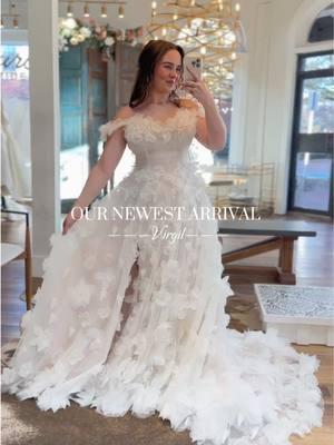 an absolute dream of a dress!!! Virgil is an off the shoulder gown with sweet flower appliqués and a show stopping statement train! We can’t wait to see y’all try her on!!! #weddingdress #flowerweddingdress #gardenparty #gardenpartywedding #floralweddingdress #whimsicalweddingdress #weddingtiktok #offtheshoulderdress 