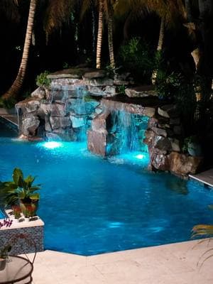 Our pools shine bright at night. Check out this beautiful Modern Zen Pool with a Natural Rock Grotto in Miami, Florida. #insanepools #lucaslagoons #zen #pooldesign #modernpool #pool 