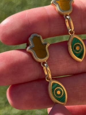 Did you know? The Hamsa and Evil Eye have been revered for centuries across various cultures, symbolizing protection from negativity and the attraction of good fortune. These timeless emblems are believed to safeguard energy and amplify positive intentions. Paired with the empowering Tiger’s Eye and the transformative energy of Malachite, they form a powerful blend of strength, protection, and spiritual growth, fostering balance and resilience.🪬 #earring #jewelrytiktok #jewelrystyle #malachite #evileye #hamsa #tigerseye #unboxing #everydaystyle 