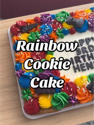 Rainbow cookie cake with candy melt vehicles! Classic black and white balance with all of the colors of the rainbow. I used a 4B tip for Red, Yellow, & Blue and a 1M tip for Orange, Green & Purple. #cookiecakedecorating #cookiecakes #americanbuttercream #jillofalltreats #microbakery #decoratewithme #chocolatechipcookie #chocolatechipcookiecake #cookiecake #CapCut #rainbowcake 