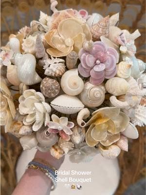 Now everyone tell my mom how talented she is 🫡 !!! Crying again at my bridal shower shell bouquet gifts handmade by my queen of a mother 🐚👰🏼‍♀️🤍 #bridalshower #familyheirlooms #shellbouquet #2025bride #weddingtiktok #bridetobe #weddingtok #bridalshowerideas #rehearsaldinner #coastalwedding #beachwedding 