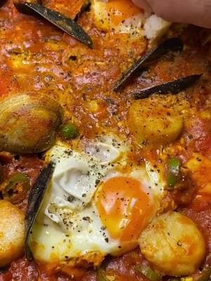 SPICY SEAFOOD OJJA 🍳🐙🦐  ‘Ojja’ is a Tunisian quick fix of eggs in tomato sauce; it is very different from shakshuka which is more like a slow-cooked veggie mix that may or not be finished off with eggs 🥚 The term ‘ojja’ refers to the fact that eggs are stirred into the sauce as it’s cooking 🍳 Seafood Ojja is one of the more colorful versions of ‘ojja’ and is typical of the coastal regions of Tunisia. It incorporates a mix of various seafood items including mussels, calamari, shrimp, octopus, etc. Today we’ve used a mix of mussels, littleneck clams, jumbo shrimp, and scallops 🦐 The full recipe can be found in the ‘Recipes’ section of our website zwitafoods.com 🌶️ You can find our traditional harissa paste at your local H-E-B ( @heb ) or by ordering directly online off our website zwitafoods.com or Amazon! 🌶️ #harissa #ojja #tunisian #tunisianfood #tunisianfoodies #eggs #Recipe #northafrican #northafricanfood #spicy #harissapaste  #tunisian_tik_tok #northafricantiktok 