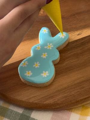 A daisy printed bunny for the ultimate Spring cookie design! 🌼I started by flooding the base of my cookie then immediately used a white flood royal icing to pipe my daisy petals and yellow for the center- working quickly before the base icing started to dry. I let my cookie dry overnight and used a fine tip edible marker to outline the flowers and finished it off with a bushy bunny tail🐰 #spring #springbaking #springcookies #easter #eastercookies #cookies #cookiedecorating #cookievideo #decoratedcookies #sugarcookies #royalicing #royalicingcookies #cookiesoftiktok #tutorial #cookietutorial #cookiedesign 